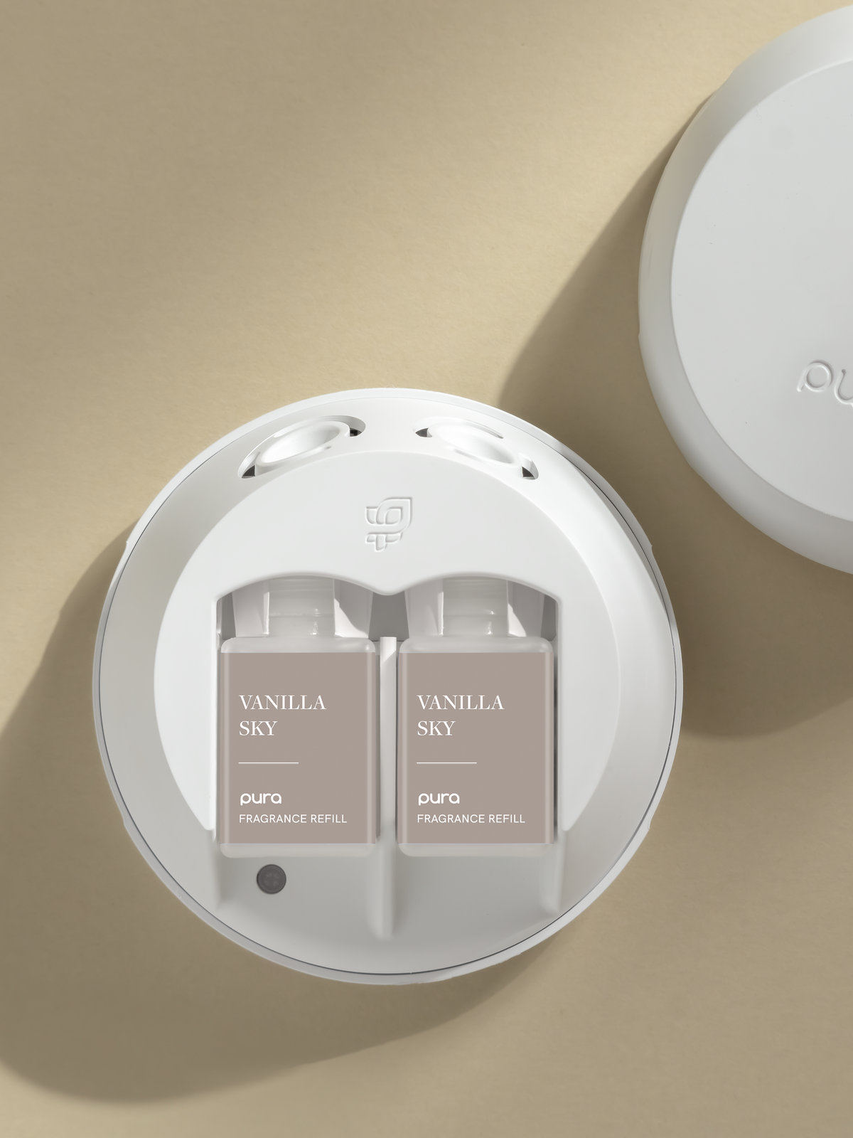 Pura Vanilla Sky fragrance refills in a Pura diffuser on a beige background
